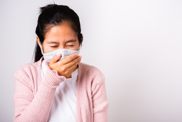 Mujer asiática con protección facial mascarilla higiene contra coronavirus y su estornudo mano cerrar boca