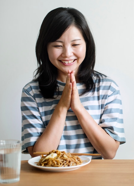 Mujer asiática a punto de comer fideos