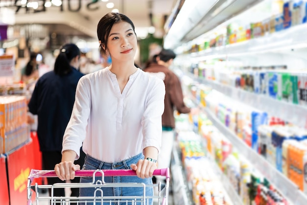 Mujer asiática que va al supermercado a comprar provisiones