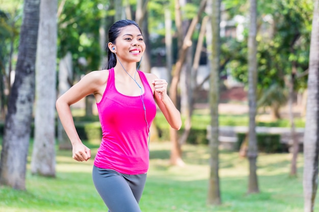 Mujer asiática que se ejecuta en el parque para la aptitud