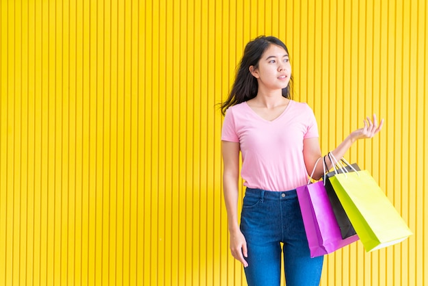 Mujer asiática que sostiene bolsos de compras