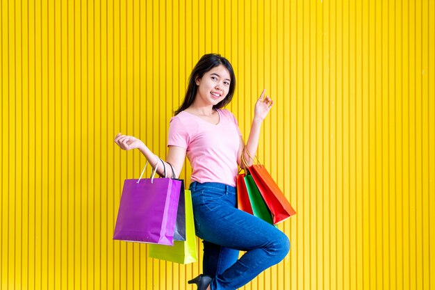 Mujer asiática que sostiene bolsos de compras