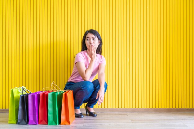 Mujer asiática que sostiene bolsos de compras