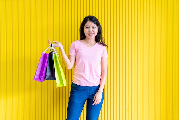 Mujer asiática que sostiene bolsos de compras