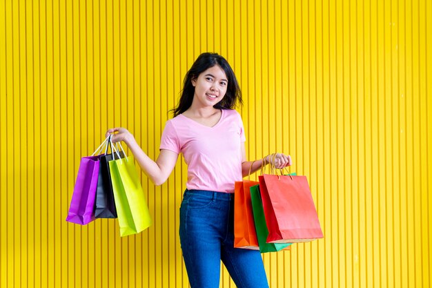 Mujer asiática que sostiene bolsos de compras