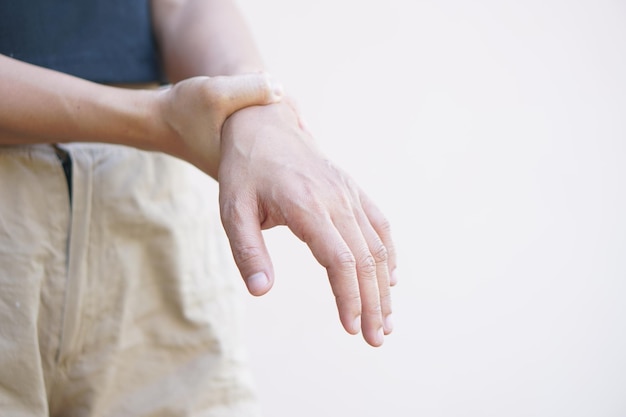 Mujer asiática que tiene entumecimiento de la mano