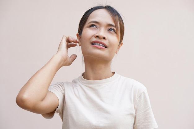 Mujer asiática que tiene picazón en los oídos