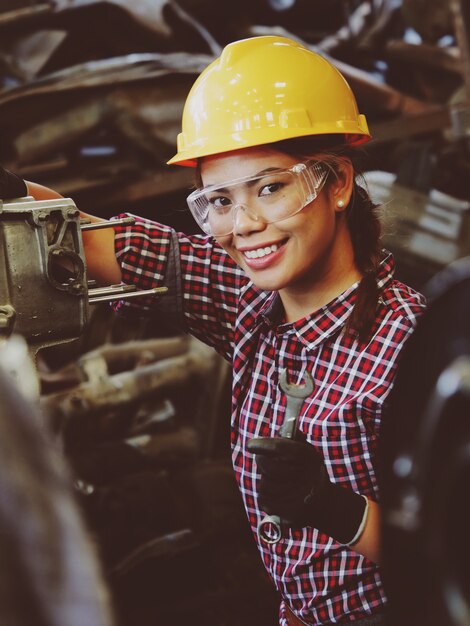 Mujer asiática que trabaja en el garaje de la fábrica