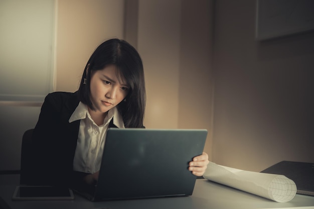 Mujer asiática que trabaja en la oficina Mujer de negocios joven estresada por la sobrecarga de trabajo con un montón de archivos en el escritorio Gente tailandesa pensando en algo