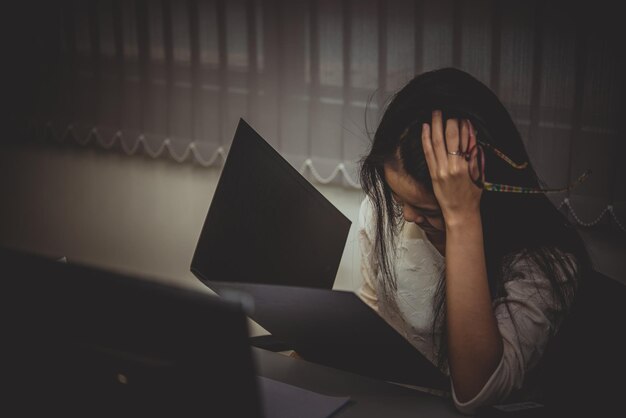 Mujer asiática que trabaja en la oficina Mujer de negocios joven estresada por la sobrecarga de trabajo con mucho archivo en el escritorio Gente de Tailandia