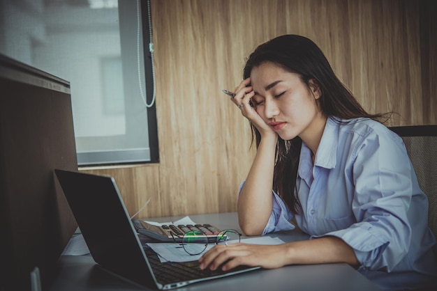 Mujer asiática que trabaja en la oficina Mujer de negocios joven estresada por la sobrecarga de trabajo con mucho archivo en el escritorio Gente de Tailandia