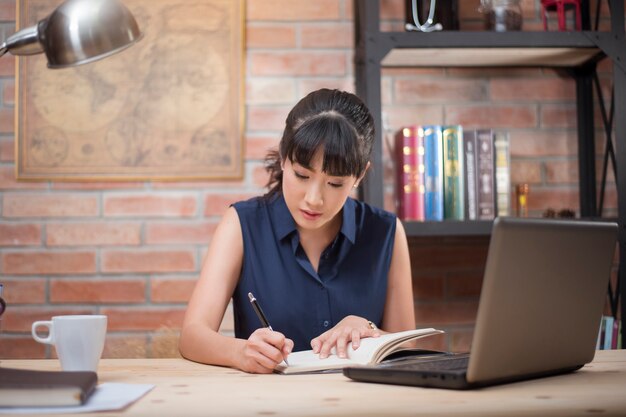 Mujer asiática que trabaja en su oficina