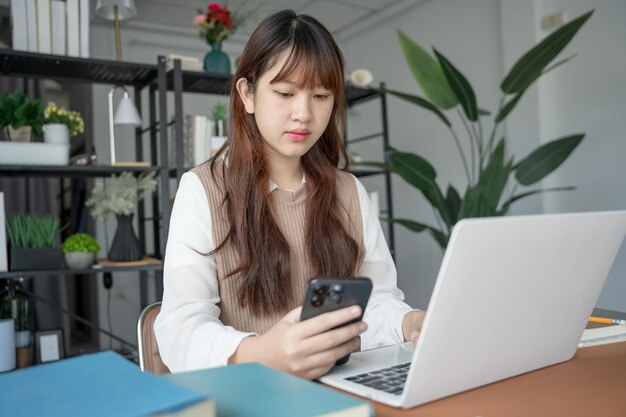 Mujer asiática que usa una computadora portátil para estudiar estudiante involucrado en aprendizaje en línea en la universidad