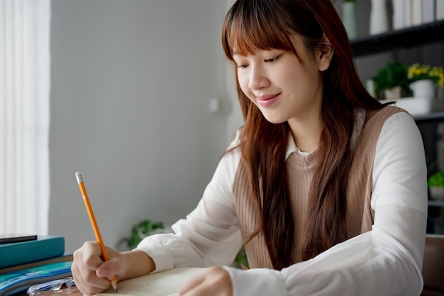 Mujer asiática que usa una computadora portátil para estudiar estudiante involucrado en aprendizaje en línea en la universidad