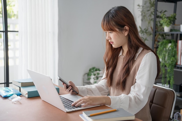 Mujer asiática que usa una computadora portátil para estudiar estudiante involucrado en aprendizaje en línea en la universidad