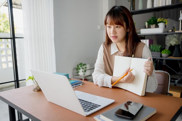 Mujer asiática que usa una computadora portátil para estudiar estudiante involucrado en aprendizaje en línea en la universidad