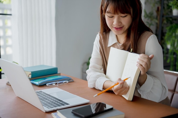 Mujer asiática que usa una computadora portátil para estudiar estudiante involucrado en aprendizaje en línea en la universidad