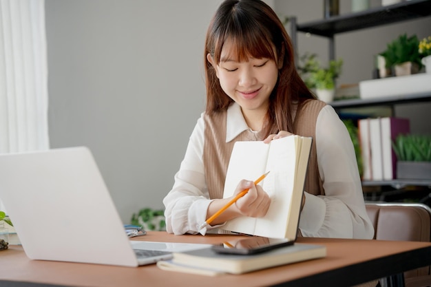 Mujer asiática que usa una computadora portátil para estudiar estudiante involucrado en aprendizaje en línea en la universidad