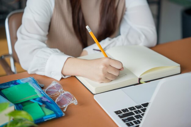 Mujer asiática que usa una computadora portátil para estudiar estudiante involucrado en aprendizaje en línea en la universidad