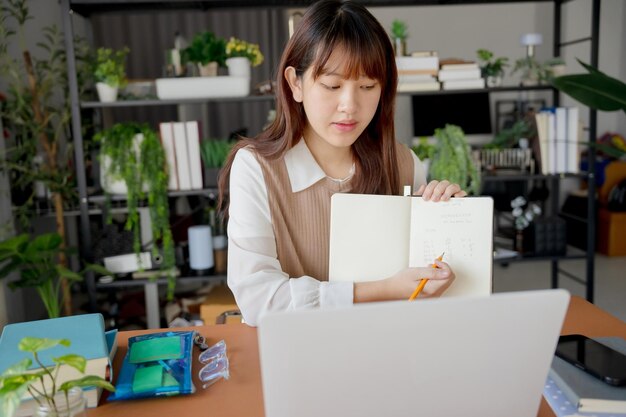 Mujer asiática que usa una computadora portátil para estudiar estudiante involucrado en aprendizaje en línea en la universidad