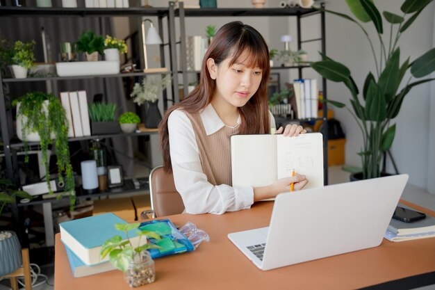 Mujer asiática que usa una computadora portátil para estudiar estudiante involucrado en aprendizaje en línea en la universidad