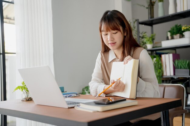 Mujer asiática que usa una computadora portátil para estudiar estudiante involucrado en aprendizaje en línea en la universidad