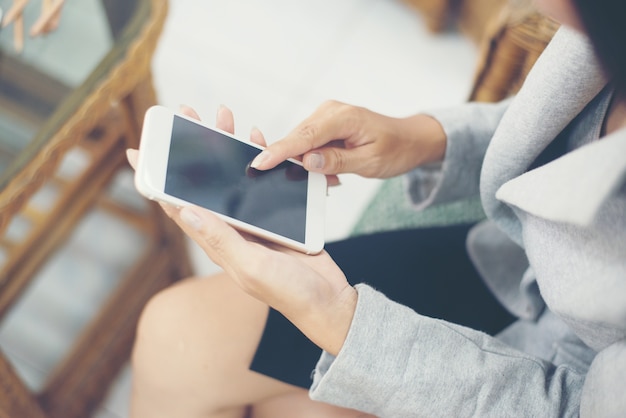 Mujer asiática que usa la tableta en café que bebe el café.