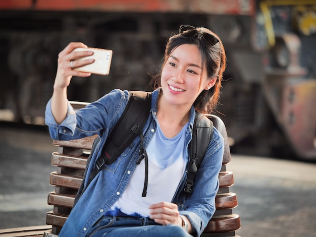 Mujer asiática que viaja con teléfono móvil