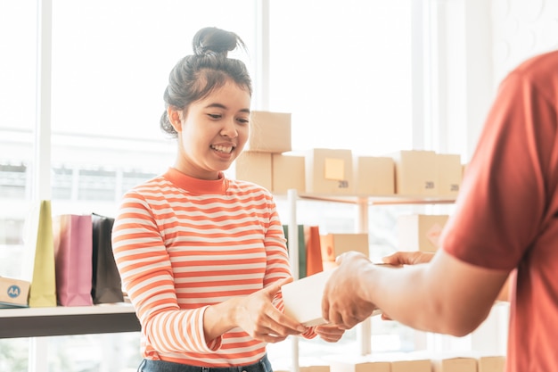 Mujer asiática recibiendo paquete de entrega