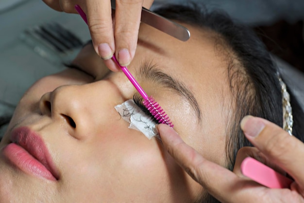 Foto mujer asiática recibiendo tratamiento de extensión de pestañas