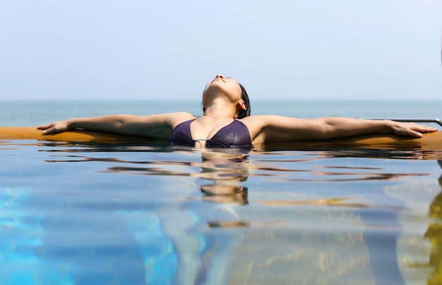 Foto mujer asiática relajante en bikini en tailandia