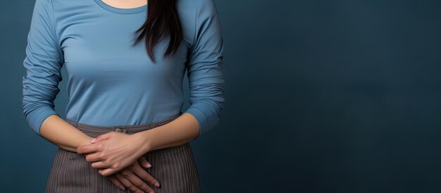 Una mujer asiática con ropa en capas que muestra una palma vacía y apoya la otra mano en la cintura