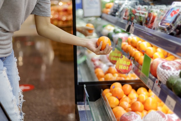 Foto mujer asiática en ropa casual de compras en el supermercado