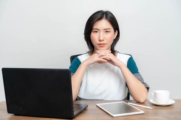 Mujer asiática sentada con cara seria en la oficina El concepto de traer trabajo desde casa en línea