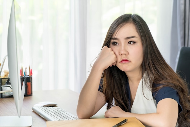 mujer asiática seria en la oficina