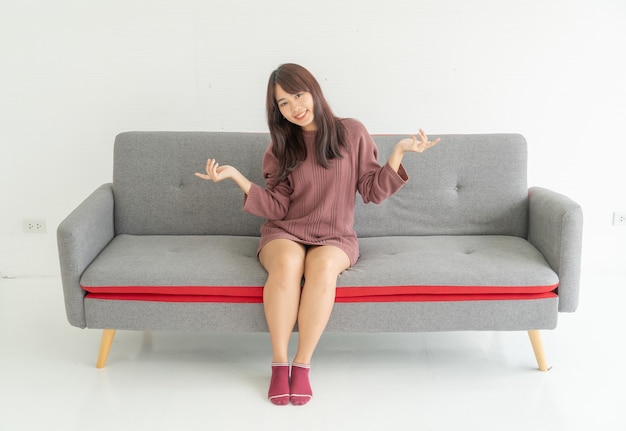 Mujer asiática en el sofá en la sala de estar con espacio de copia