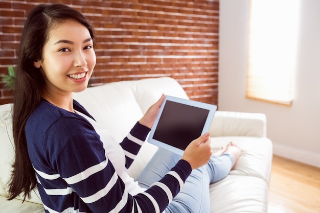 Mujer asiática en el sofá con tableta