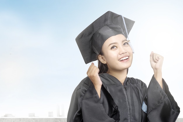 Mujer asiática en sombrero de birrete graduarse de la universidad