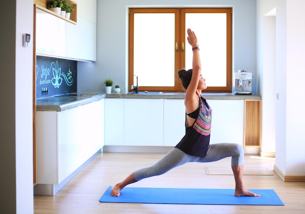 Mujer asiática son ejercicios de yoga en casa