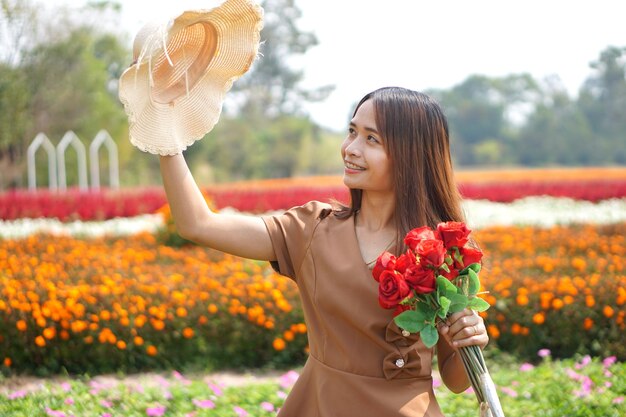 Mujer asiática sonriendo felizmente entre hermosas flores