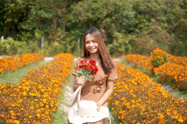 Mujer asiática sonriendo felizmente entre hermosas flores