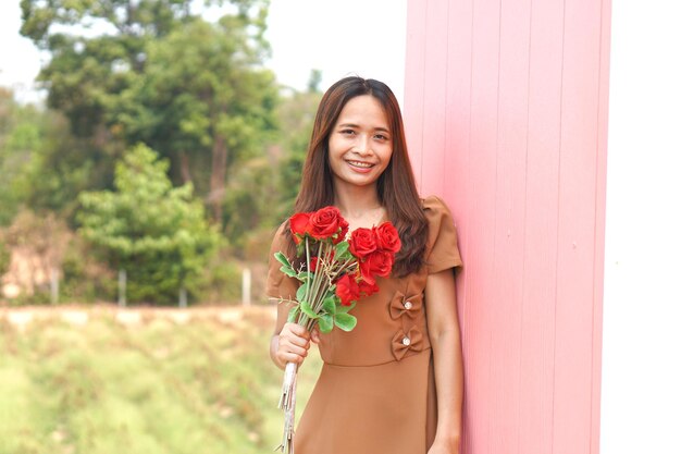 Mujer asiática sonriendo felizmente entre hermosas flores