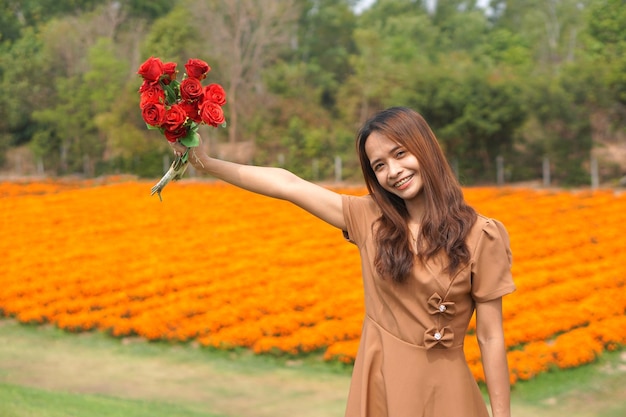 Mujer asiática sonriendo felizmente entre hermosas flores