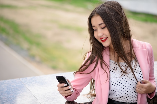 Mujer asiática sonriente con el teléfono