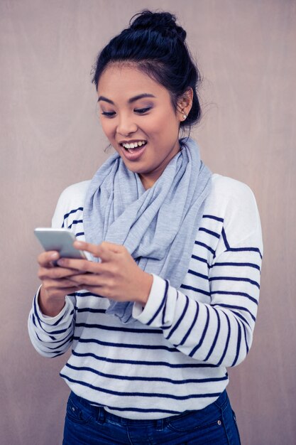 Mujer asiática sorprendida que usa la situación del smartphone