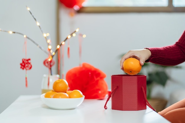 Mujer asiática sosteniendo mandarinas con caja de regalo roja presente agradecido Año Nuevo Lunar Fiesta tradicional china Cultura del año nuevo lunar