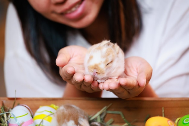 Mujer asiática sosteniendo un pequeño conejito en la mano con ternura y amor La gente cuida a una mascota y decora el hogar para Pascua Felices Pascuas Felices fiestas