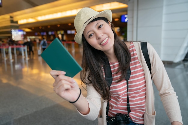 mujer asiática sosteniendo su pasaporte felizmente. con la cara feliz sonriente.