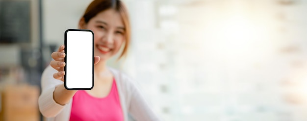 Mujer asiática sosteniendo un teléfono de pantalla en blanco blanco de pie delante de la pantalla en blanco del teléfono inteligente para la aplicación de teléfono inteligente de publicidad Ideas de collage de fotos para espacio de copia de anuncios