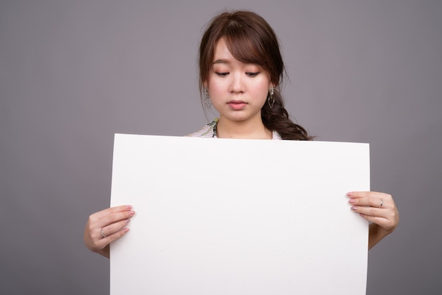 Mujer asiática con tablero blanco vacío con copyspace